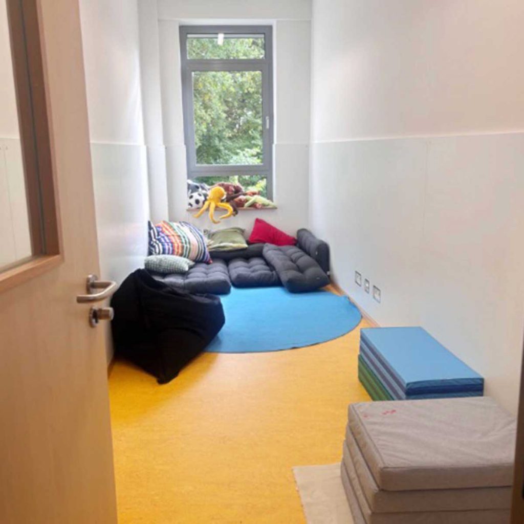 Ein kleiner Raum mit Matten und Kissen, die auf dem Boden liegen.