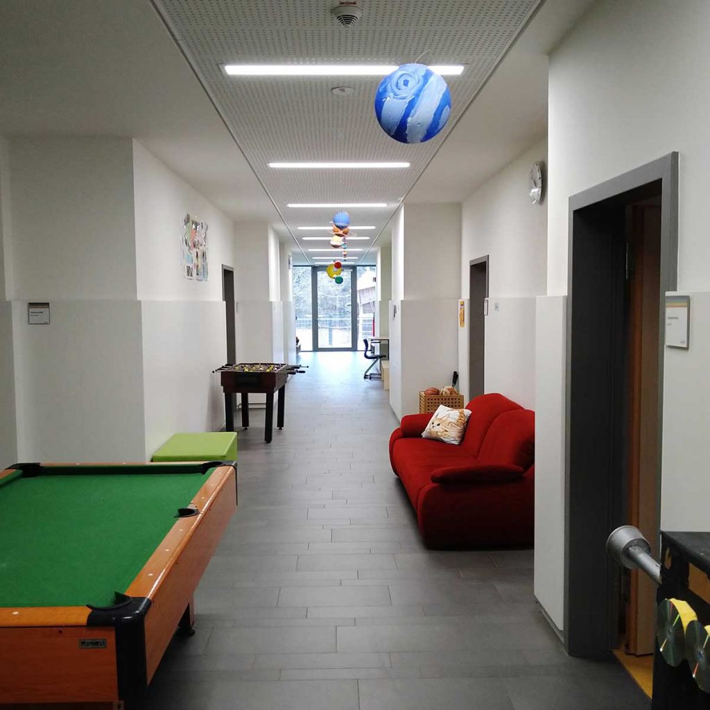 Ein Flur, darin ein Billardtisch, am Ende ein Fenster